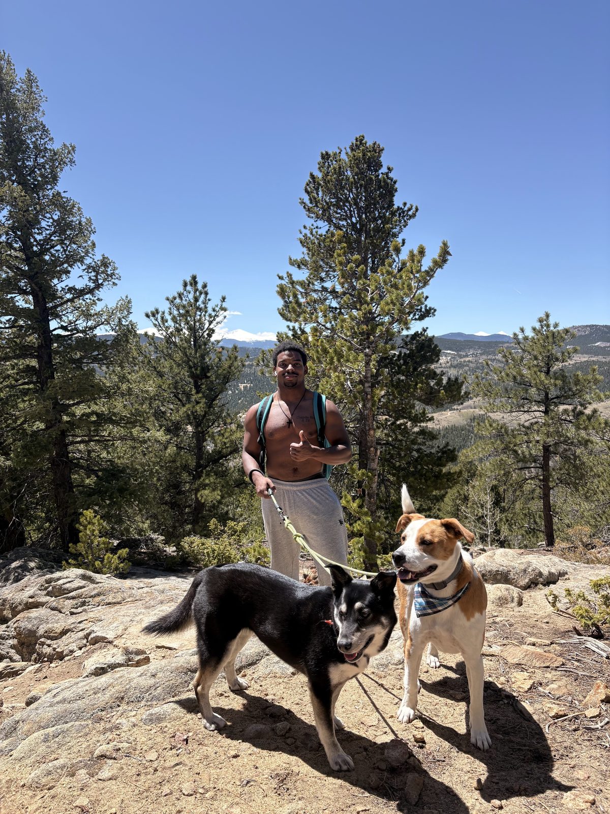 JD hiking with two client dogs above a reservoir near Red Rocks, Colorado