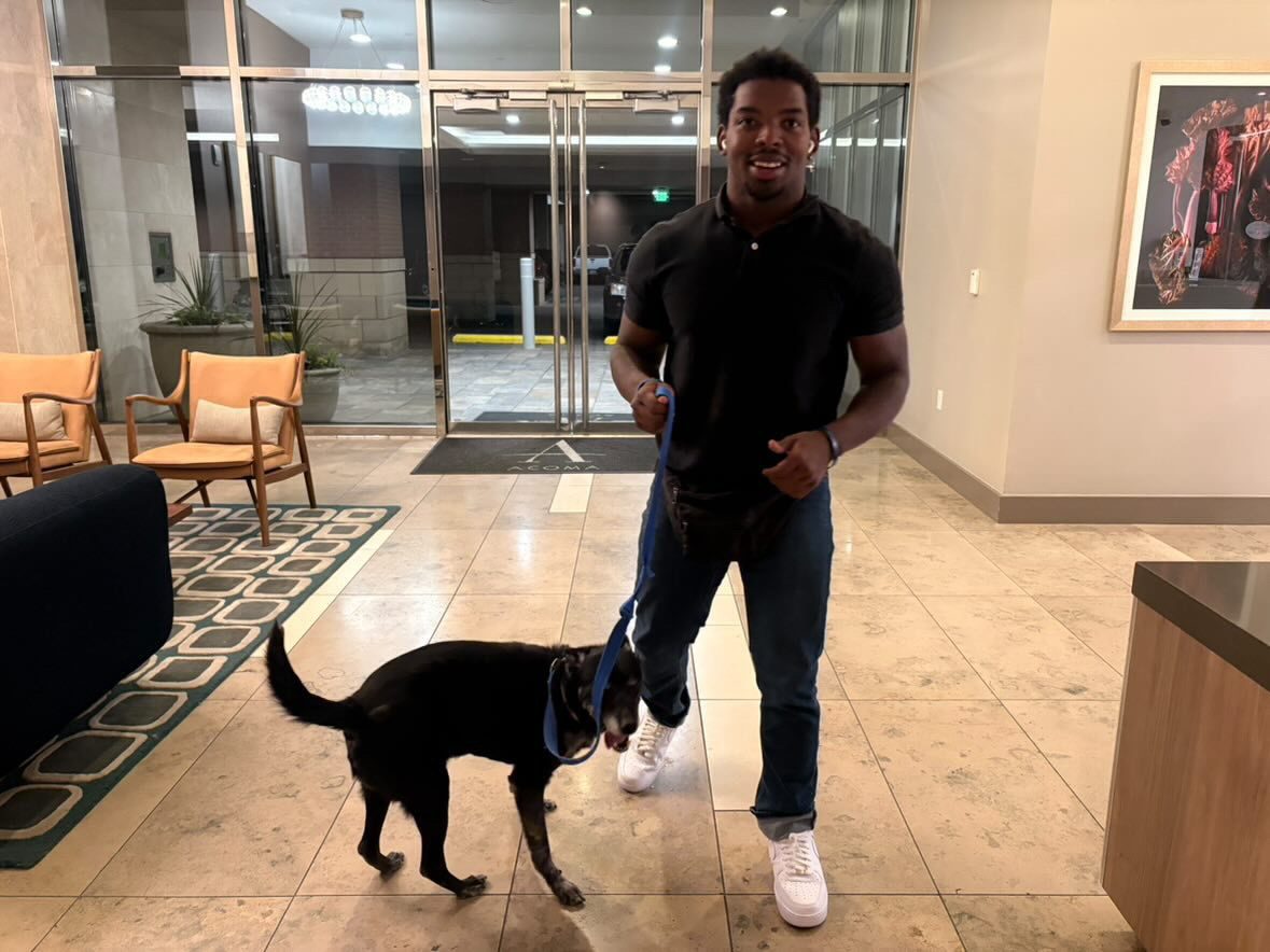 JD walking a client dog through a Denver building lobby