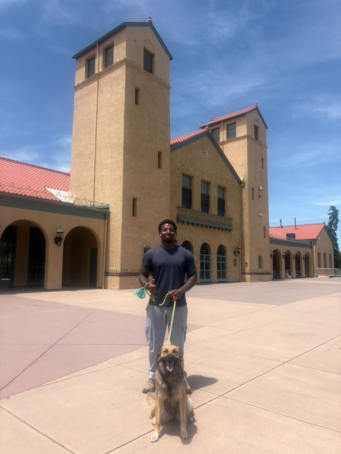 JD and a client dog in front of a Denver landmark building
